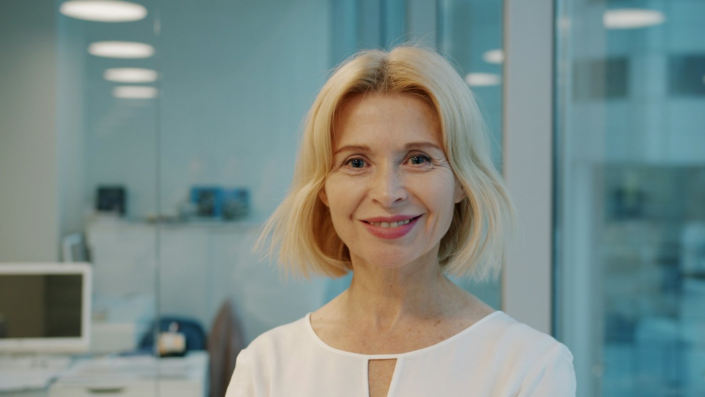 Femme souriante d'une cinquantaine d'années dans un bureau